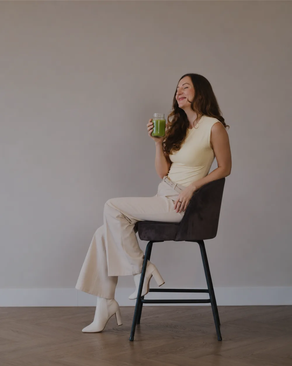 Lucinda Allen, nutritional therapy practitioner, seated with a green smoothie